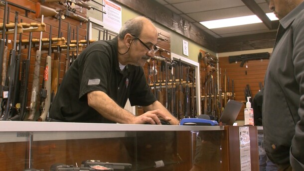 A customer looks at guns inside AO Sword Firearms in El Cajon, March 23, 2020.