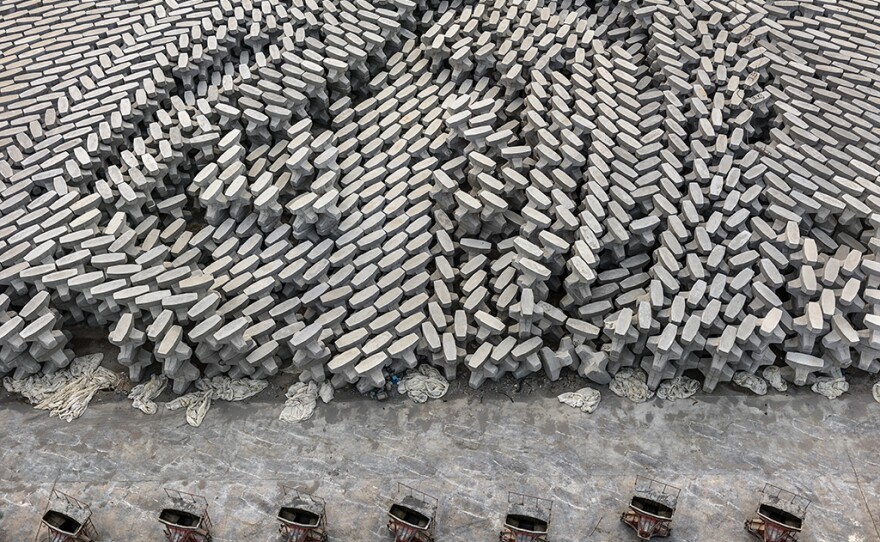 A tetrapod factory in Dongying, China. These concrete blocks are dropped into the ocean to create a barrier that protects low-lying oil refineries from rising sea levels. According to a recent scientific review, human beings have now produced enough concrete to cover the entire globe in a 2-millimeter thick layer.