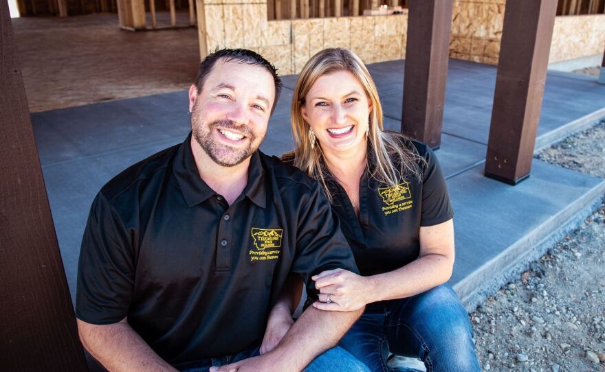 Home builder Tom Stringham sits with his wife Angela Stringham in front of a home his company is building in Montana.