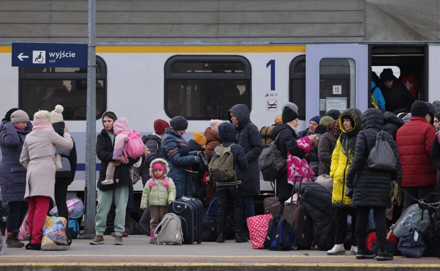 People arriving from Ukraine wait at the main railway station for a train to take them to Warsaw on Monday in Przemysl, Poland.