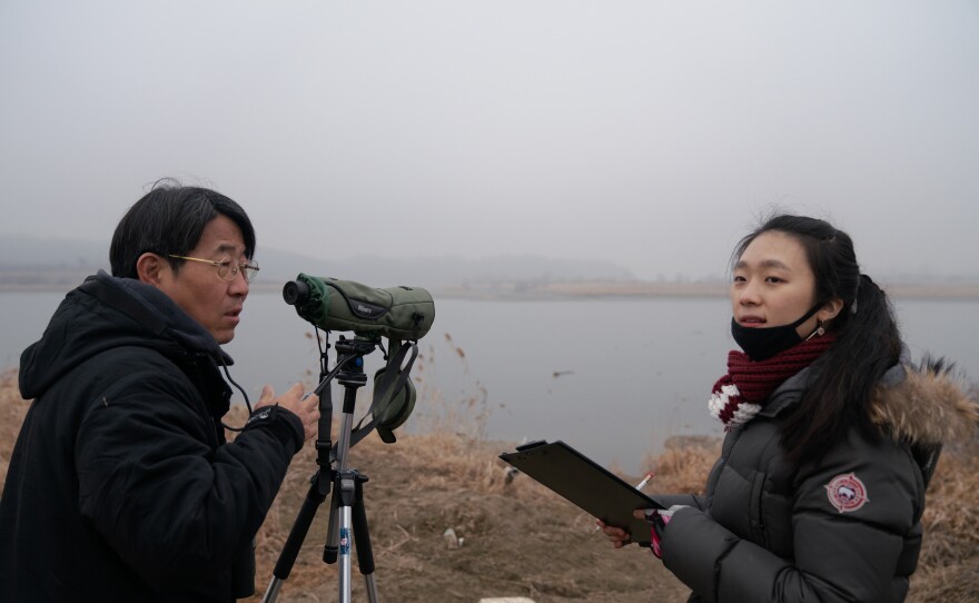 Kim Seung-ho (left), the director of the DMZ Ecology Research Institute, counts birds of the DMZ with intern Pyo Gina.