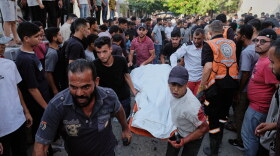Palestinians carry a body from the site of an Israeli military strike in Gaza City, Sunday, Aug. 2, 2026.