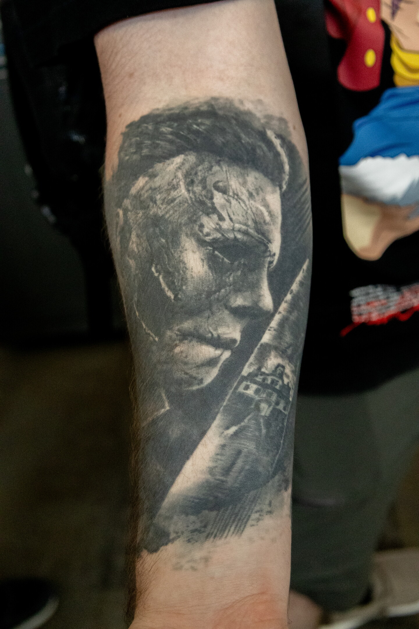 Michael Myers from the "Halloween" film series wields a knife in a classic black and white tattoo design at Comic-Con, July 23, 2026.