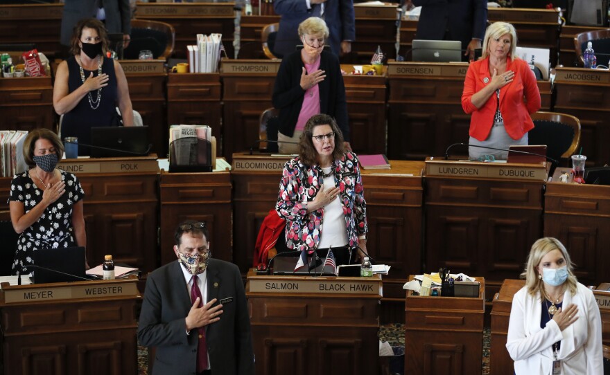 State Representatives stand at their desks during the Pledge of Allegiance in the Iowa House chambers, at the Statehouse in Des Moines, Iowa, in June.