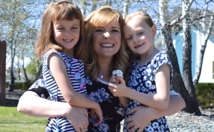 Melanie Emery hugs her two adopted daughters Grace, 6 (left) and Nevaeh, 8 (right) in this undated photo. 