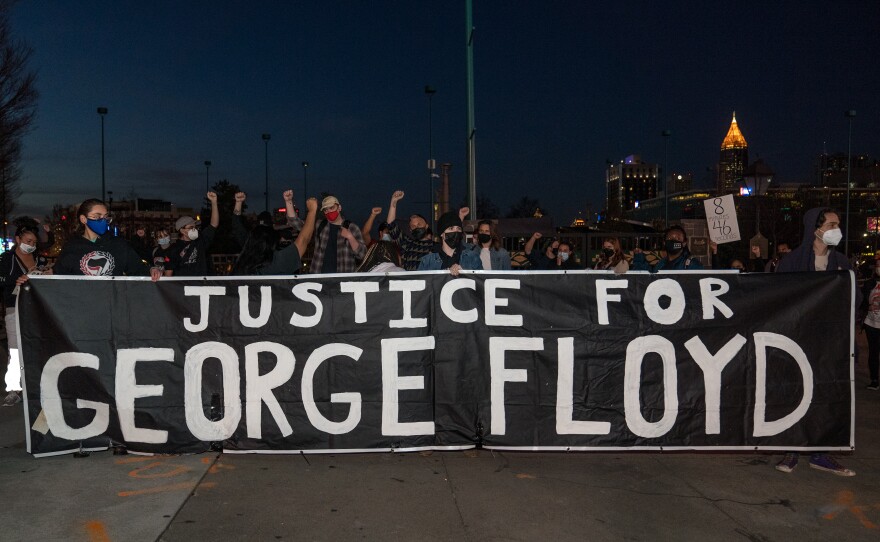 Demonstrators hold a vigil in honor of George Floyd on March 8, 2021 in Atlanta, Ga.