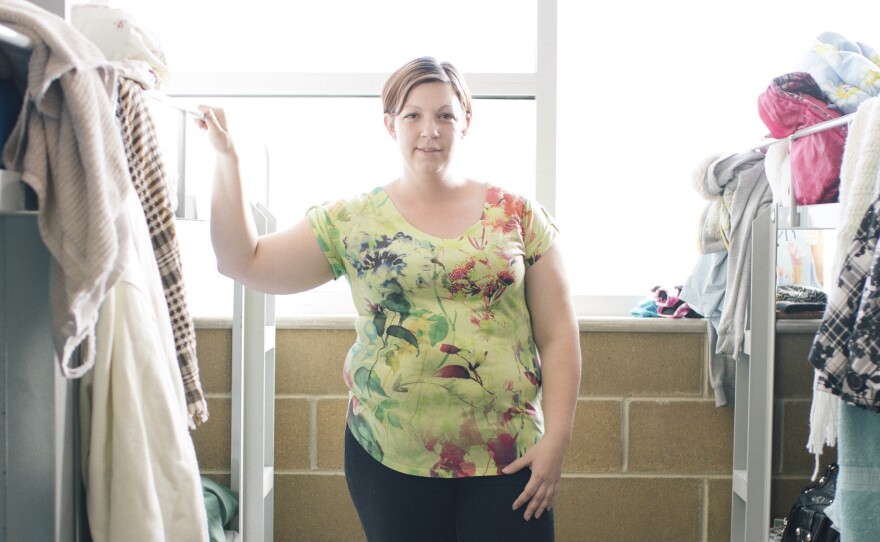 Jennifer Carter, 30, stands in a dormitory area that she shares with her two young children at The Road Home Community Winter Shelter facility in Midvale, Utah.