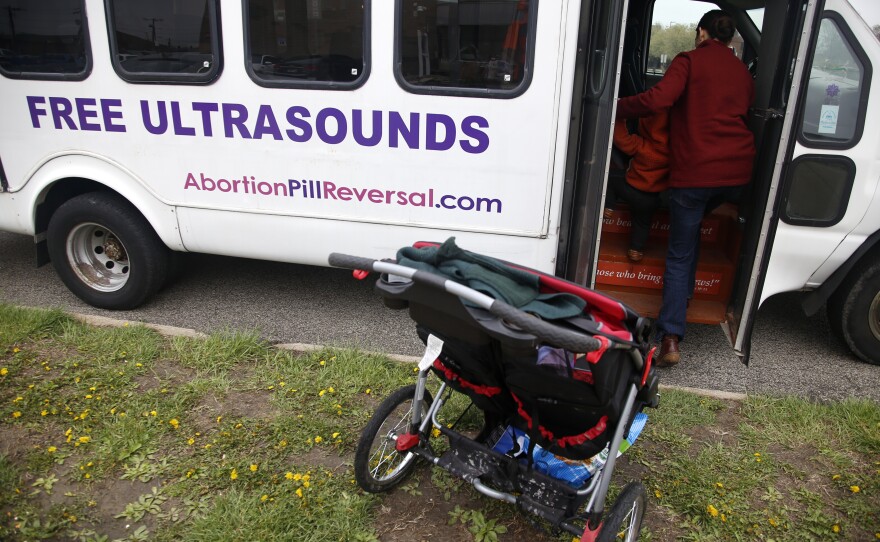 Melanie Wong walks her young son into an ultrasound van on Tuesday, April 12, 2022, outside the Hope Clinic for Women in Granite City, Ill.