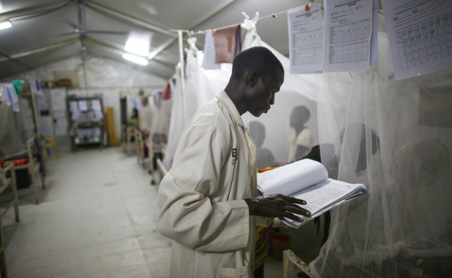 Late-night checkup: A South Sudanese nurse reviews a patient's chart.