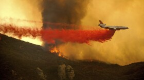 A DC-10 air tanker drops retardant to slow the Cave Fire burning in Los Padres National Forest, Calif., above Santa Barbara on Tuesday, Nov. 26, 2019. 