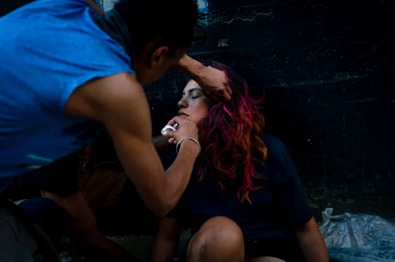 An unhoused resident injects a Narcan nasal spray into the nose of another individual who appears to have overdosed in Los Angeles on Aug. 25, 2022.