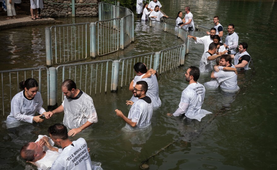 Evangelicals from Brazil wade, pray and get baptized in the Jordan river in Israel on May 11, 2024.