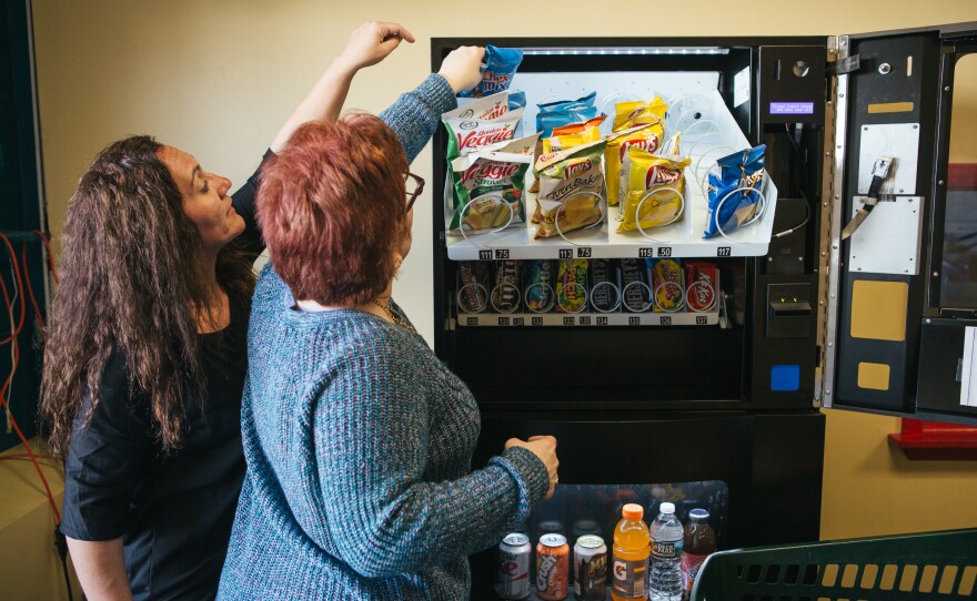 Erica Francis, a direct support professional, helps Pauline as they restock a vending machine at Arc of Northeastern Pennsylvania.