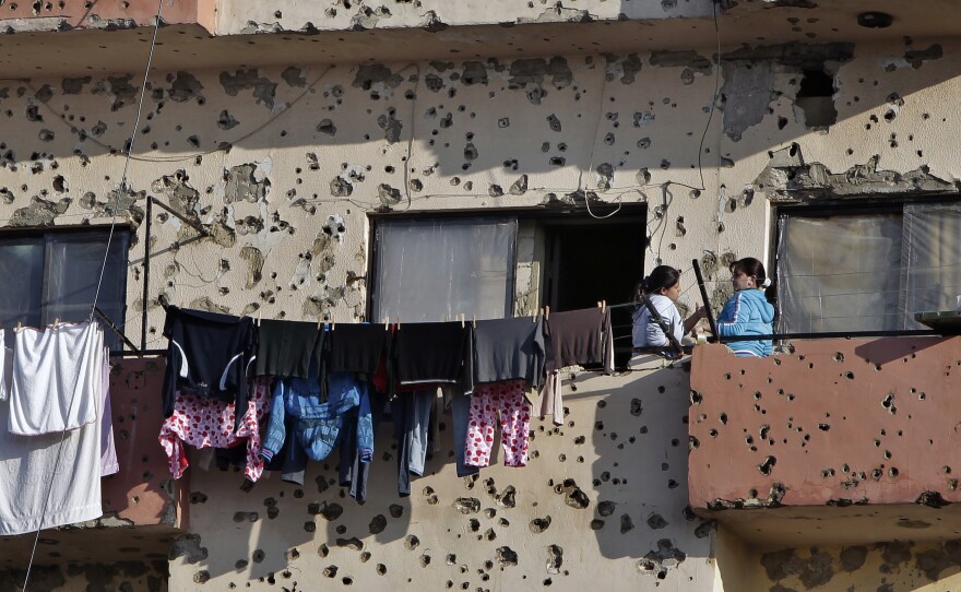 Bullet holes from recent clashes riddle an apartment building in Tripoli.