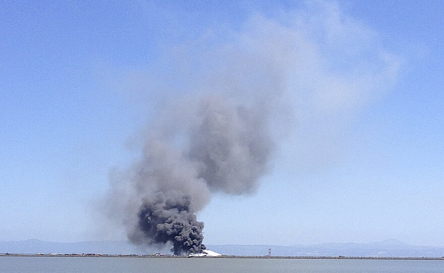 Smoke rises from the crippled Boeing 777 in this photo provided by Scott Sobczak.