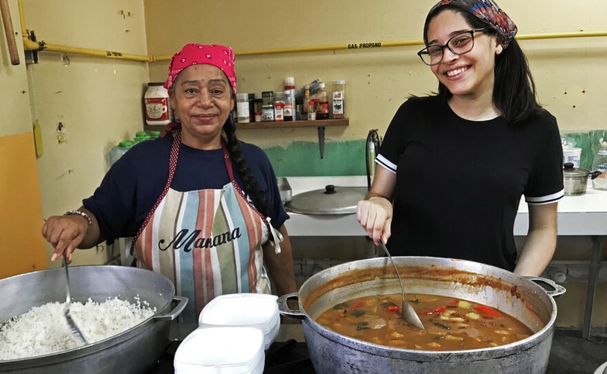 Mariseli O'Neill Fontana (right) and other volunteers serve food three times a week in Las Carolinas, a neighborhood in Caguas.