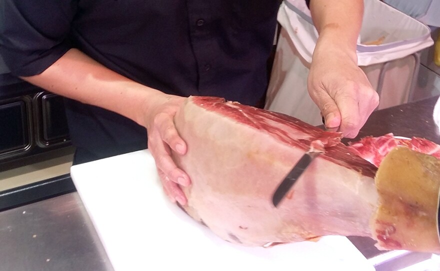 A ham cutter demonstrates how to carefully slice Spanish jamón at the Don Jamón tapas bar on Madrid's Gran Vía.