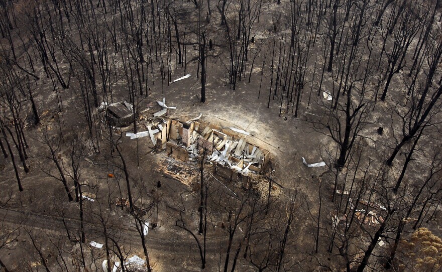 Following the catastrophic bushfires in 2009, the burned remains of a house sit among charred trees near the town of Kinglake in Australia.