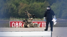 A forensic technician works alongside a bomb-disposal robot near a Ukrainian aircraft at Leipzig/Halle Airport, where a drone with an explosive device was found and a detonator was removed from the object, in Schkeuditz, Germany, Wednesday Aug. 5, 2026.