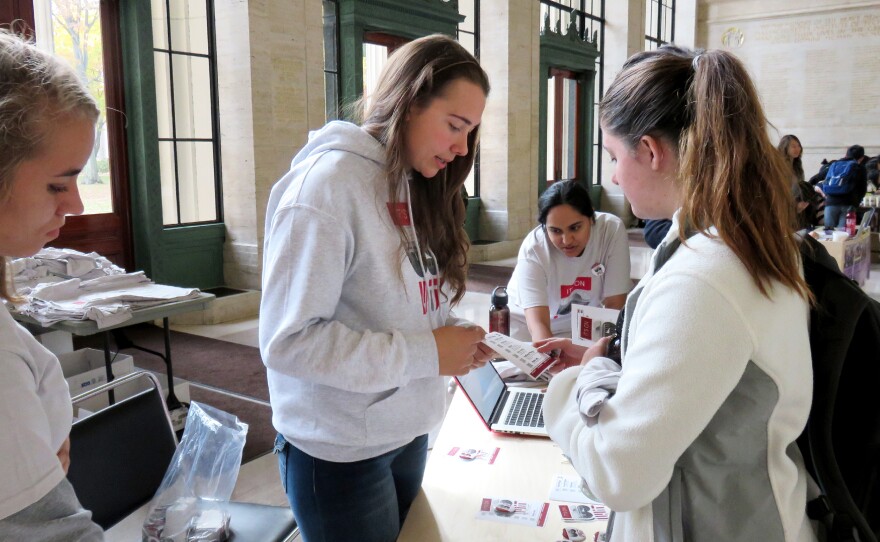 MIT student activist Larkin Sayre (center) works a booth representing the "It's on Us" campaign in a lobby on campus.