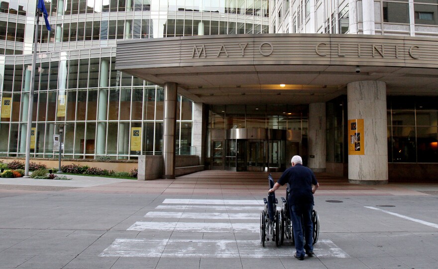 Mayo Clinic employee Merle Paxton returns wheelchairs to a building on campus.