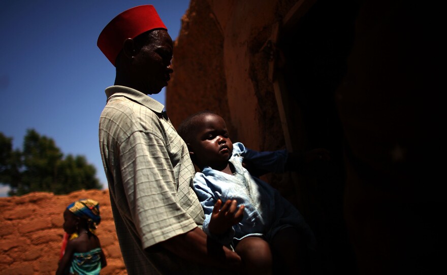 Aminu, age 4, was paralyzed by polio in August 2012. In the photo above, his father, Ado Ibrahim, carries the youngster through the village of Minjibir in northern Nigeria.