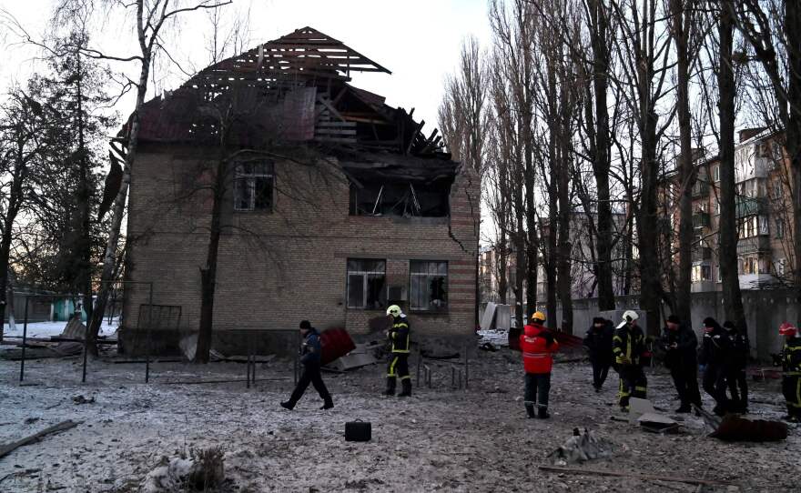 Emergency workers and police examine a building that was hit during a Russian drone strike Wednesday morning in Kyiv. Ukraine says it shot down all 13 drones that targeted the capital. The damage was apparently caused after the drone was hit and came crashing down.