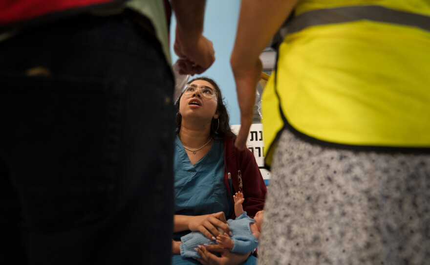 Lipaz Zira play acts as a patient with a baby in a drill in the underground hospital in Haifa.