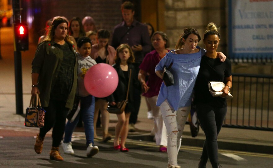 People leave Manchester Arena in England on Monday night, after an explosion that killed 22 people and wounded dozens more.