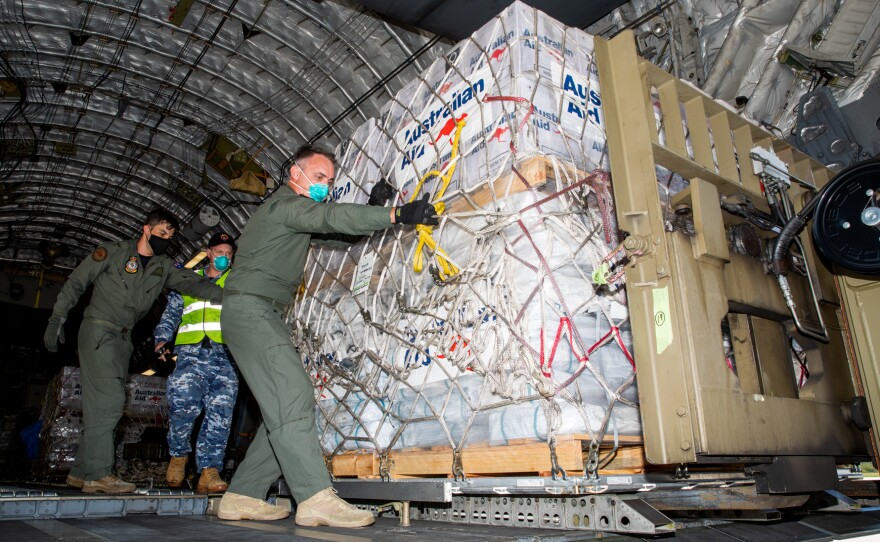 Members of the Australian Defence Force unload humanitarian supplies on Jan. 20 at Tonga's Fuaʻamotu International Airport. Then Tongans distribute the aid.