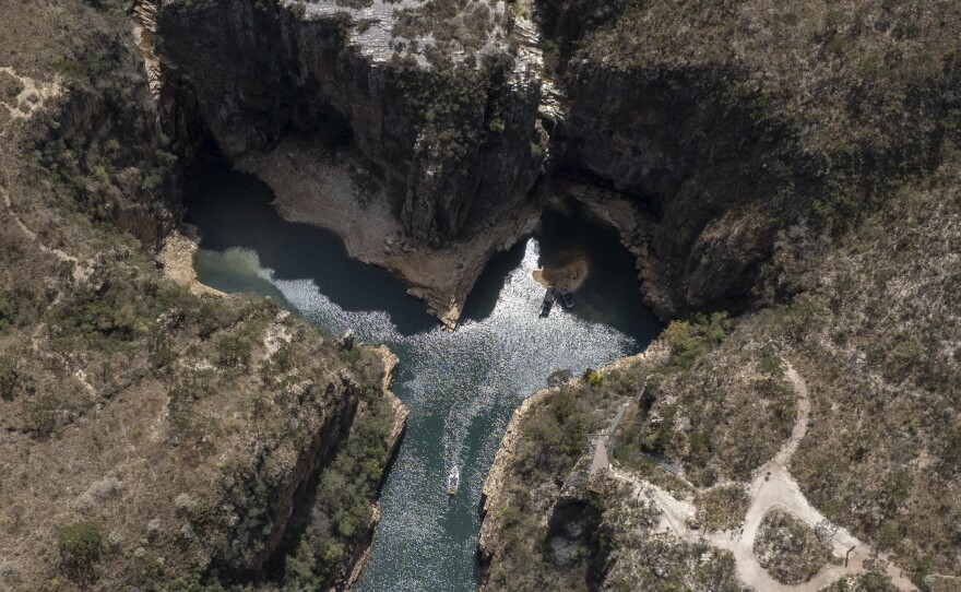 A tourist boat navigates through a canyon in Furnas Lake, near Capitolio City, Brazil on Sept. 2, 2021.