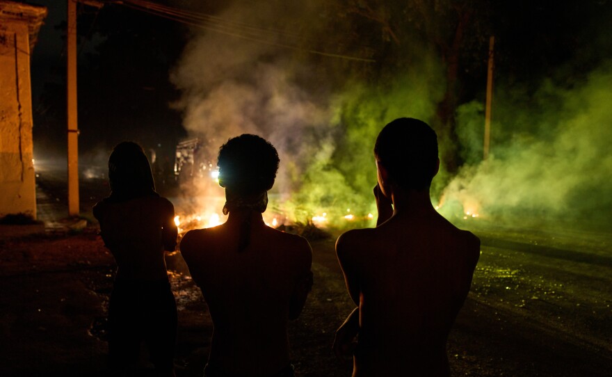 People look at a barricade set up by residents protesting against prolonged power outages in Havana, Cuba, Wednesday.