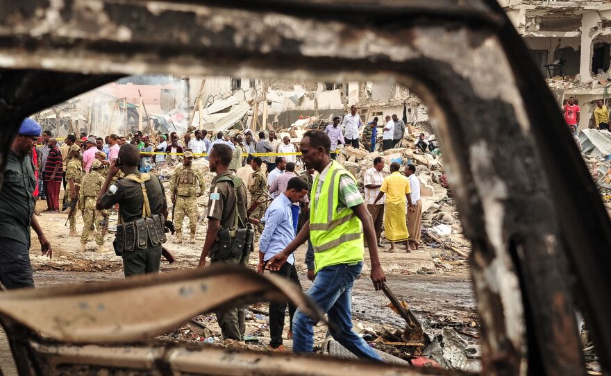Somali soldiers and rescue workers on Sunday inspect the scene of the truck bomb explosion in Mogadishu.