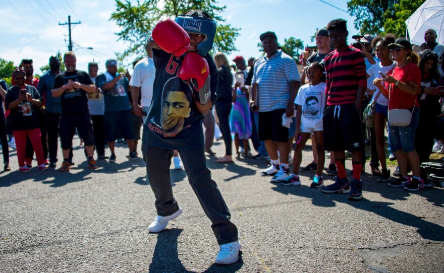 Thirteen-year-old Malik Parker shadow-boxes outside the boxing legend's childhood home.