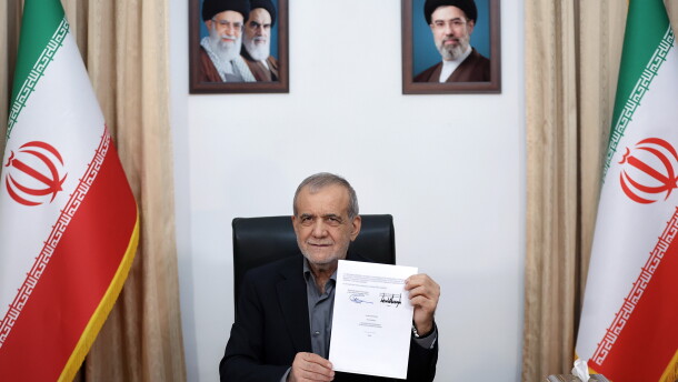 In this photo provided by the Islamic Republic News Agency (IRNA), Iranian President Masoud Pezeshkian displays a memorandum of understanding signed with U.S. President Trump aimed at ending the war and launching negotiations on a broader agreement, in Tehran, Iran, early Thursday.