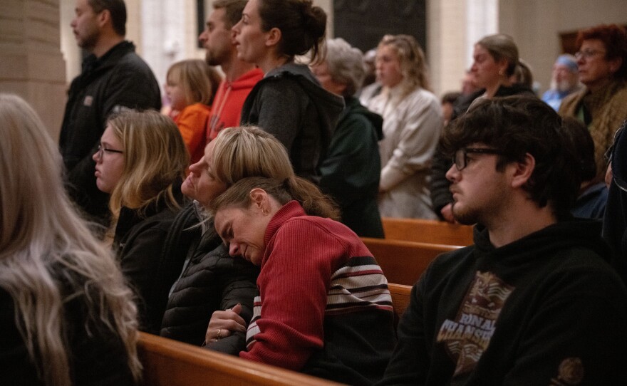 Attendees embrace as others sing along with a closing rendition of <em>Amazing Grace.</em>