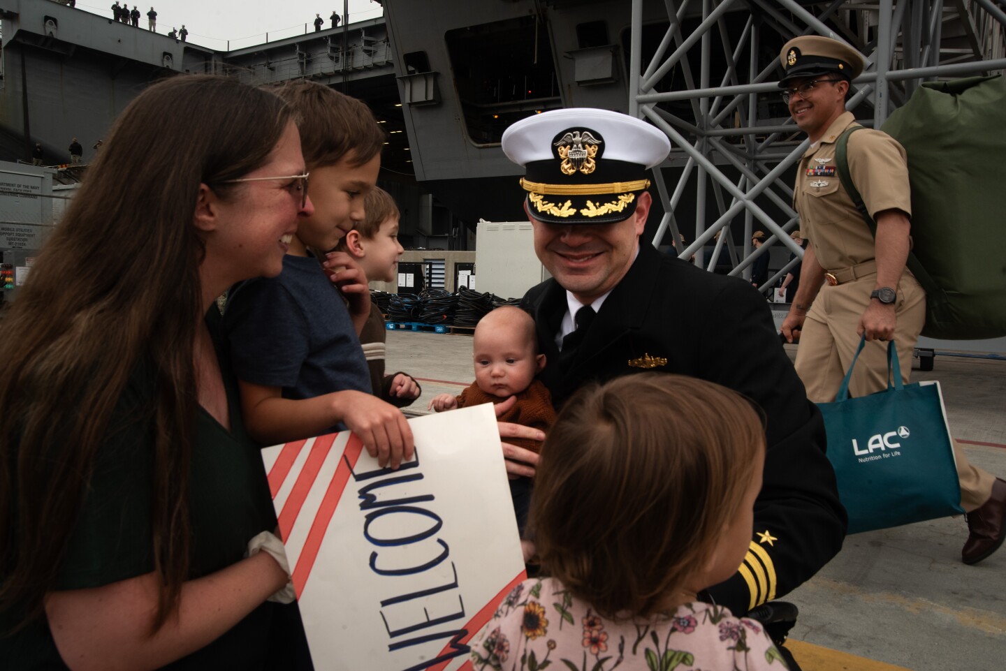 A family reunites with their loved one after he departs the aircraft carrier Theodore Roosevelt on Oct. 15, 2024 at the Naval Air Station North Island on Coronado Island.