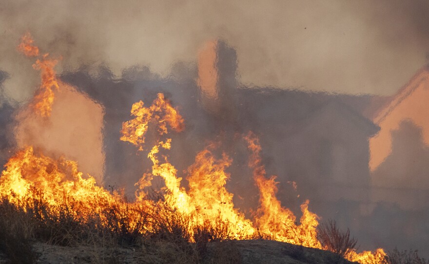 Flames approach houses during the Tick Fire on Oct. 24, 2019 in Canyon Country, California.