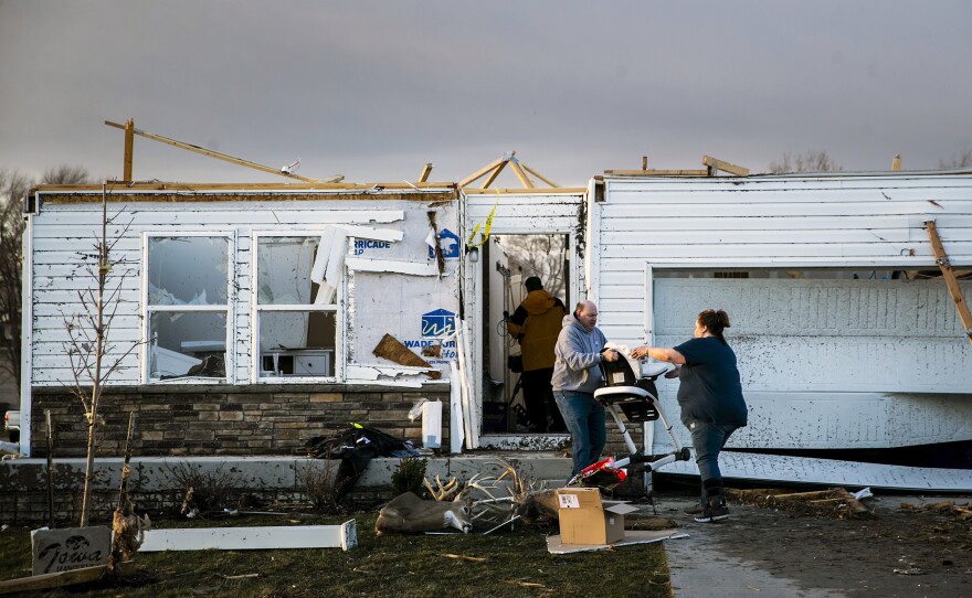 Family and friends help remove personal items from a storm damaged home after a tornado warning in Johnson County, Friday, March 31, in Hills, Iowa.