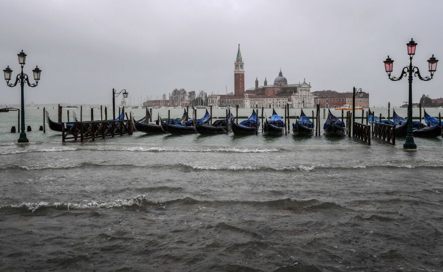 Gondolas are moored by the flooded Riva degli Schiavoni waterfront in Venice.