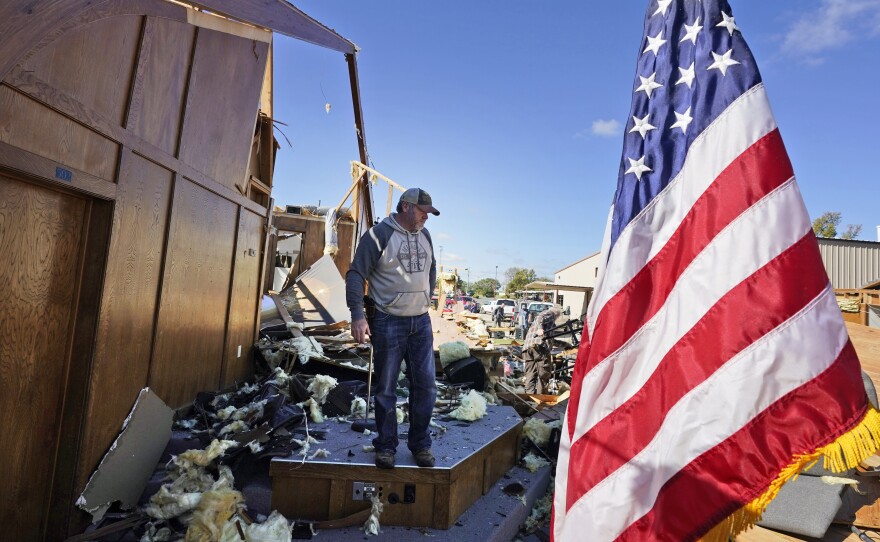 Danny Palmer, a deacon at Trinity Baptist Church, stands in the destroyed church's sanctuary on Saturday looking for items to salvage after a tornado hit in Idabel, Okla.