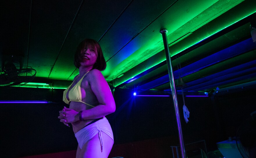 M. dances at a bar. With her income severely cut during the pandemic, she may have to move back to Isaan, the northeastern region where she grew up, and help her mother tend their small plot of rubber trees.
