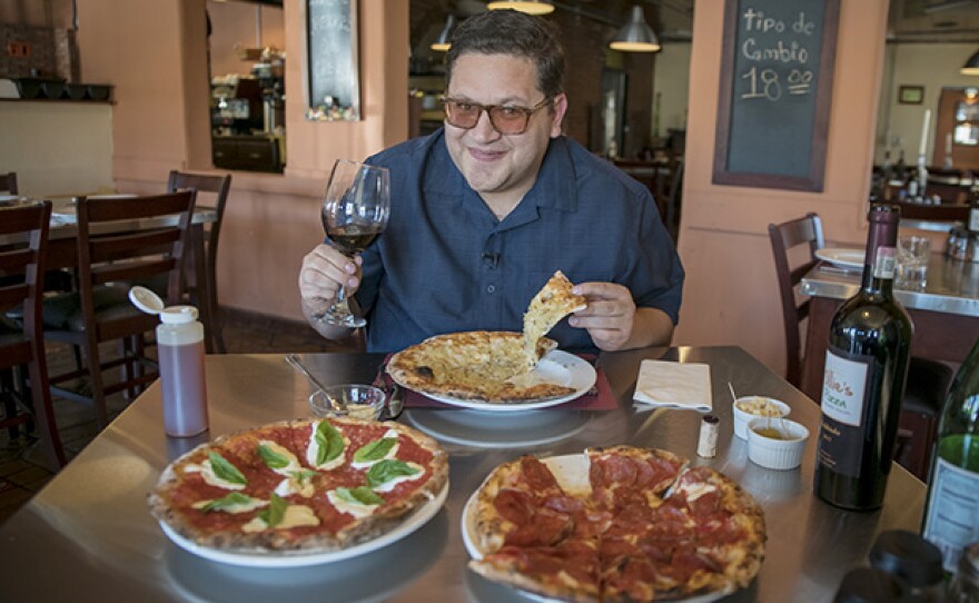Host Jorge Meraz is bursting with enthusiasm as he is about to enjoy some of the goodness served at Ollie's Pizza in Rosarito, Baja Calif.