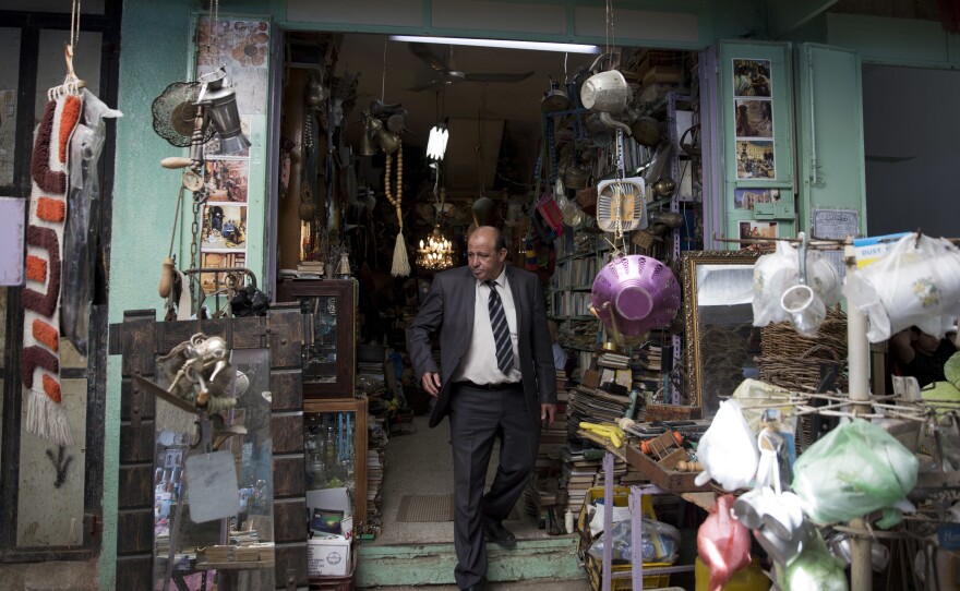 Ayman Hassouna, a Palestinian tour guide who hasn't led tourists around Gaza for 20 years, walks out of an antiques shop in the middle of the main market in Gaza's Old City.