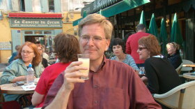 Rick Steves drinking pastis at a cafe in France. 