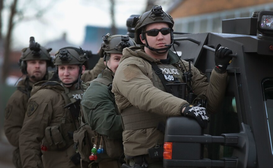 Police secure the area following a mass shooting at the Henry Pratt Co. in Aurora, Ill., on Friday. A gunman killed five people and wounded five police officers before being fatally shot by police.