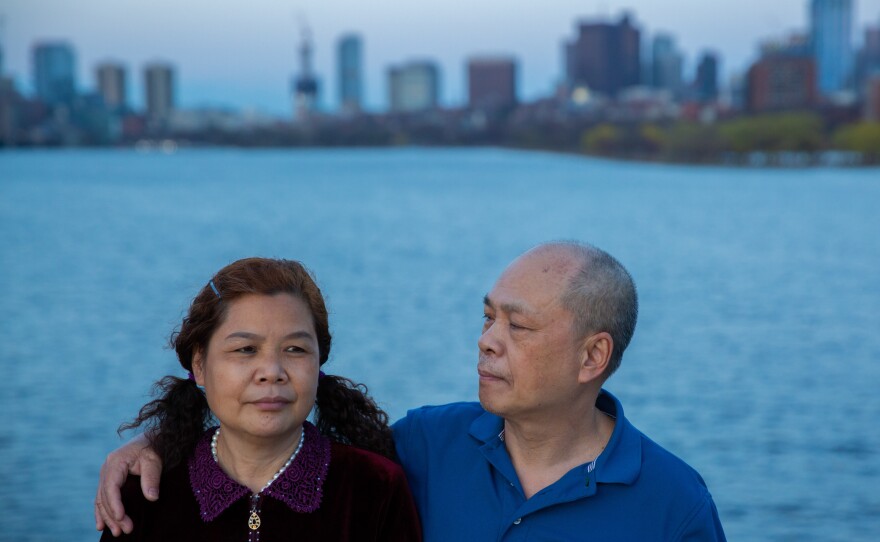 Liang Runling, 56, sits with her husband, Chen Yuning, along the Charles River in Boston.