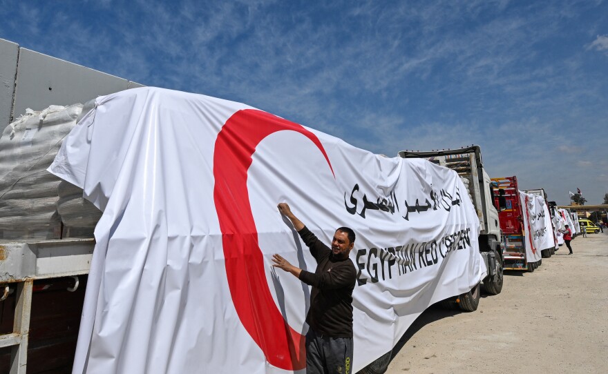 Egyptian Red Crescent trucks loaded with aid queue outside the Rafah border crossing with the Gaza Strip on March 23. After months of very limited aid deliveries to Gaza, the pace is picking up this week. More than 400 trucks are entering Gaza daily, according to Israel. This is more than double the previous rate.