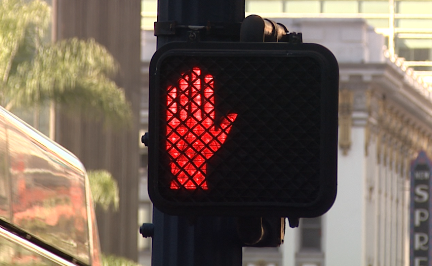 A red hand illuminates on a pedestrian crosswalk light, Feb. 21, 2017.