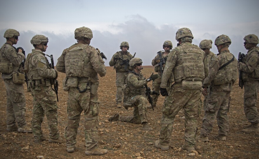 U.S. soldiers gather for a brief during a combined joint patrol rehearsal in Manbij, Syria, in November 2018. The White House says about 200 troops will remain for an unspecified period of time.